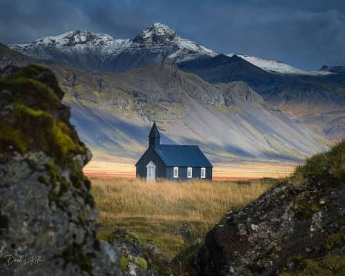 The black church at Búðir beneath the mountains in Iceland
